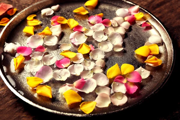 Roze en geel roze bloemblaadjes in zilveren kom — Stockfoto