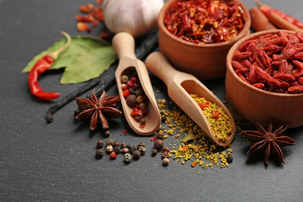 Assorted spices on black table background — Stock Photo, Image