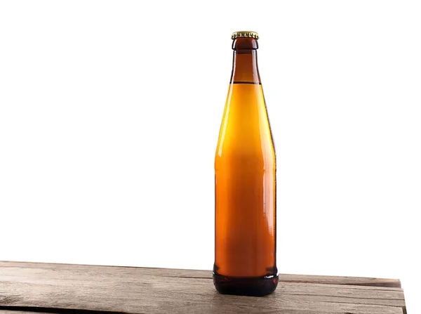 Unlabeled beer bottle on wooden table against white background — Stock Photo, Image