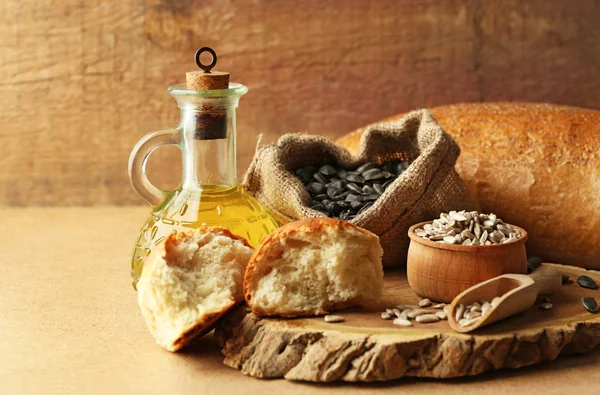 Composição de sementes de girassol, pão e óleo sobre fundo bege, close-up — Fotografia de Stock