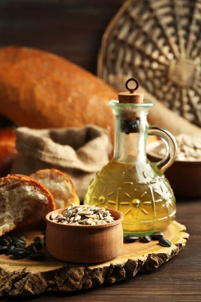 Slunečnicová semena, chléb a olej na dřevěný stůl pozadí, záběr — Stock fotografie