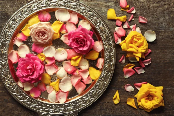 Rosa y amarillo pétalos de rosa en tazón de plata — Foto de Stock