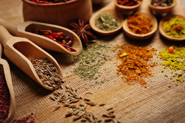 Assorted spices in spoons on wooden table closeup — Stock Photo, Image