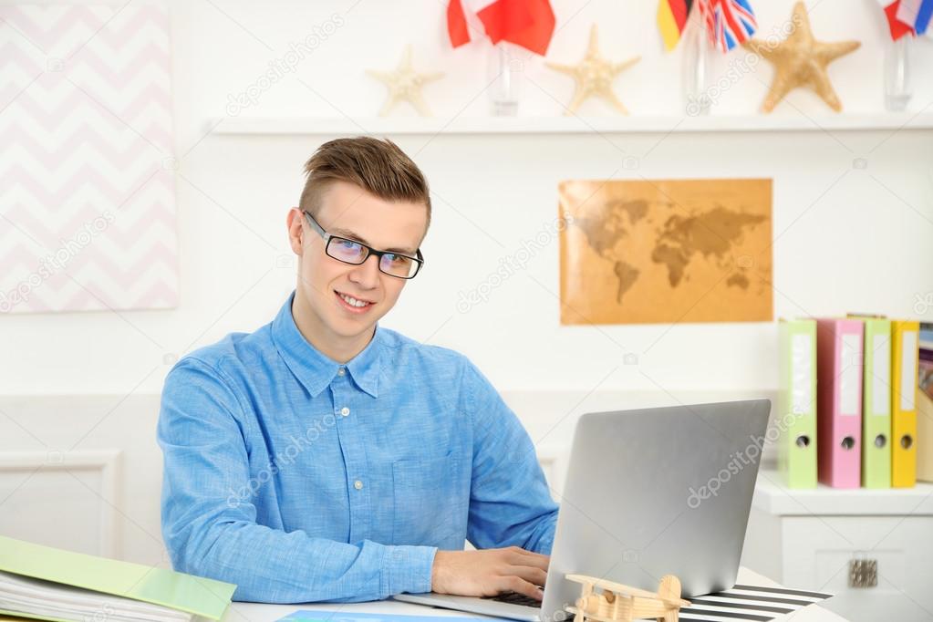 Young man in the office of travel company