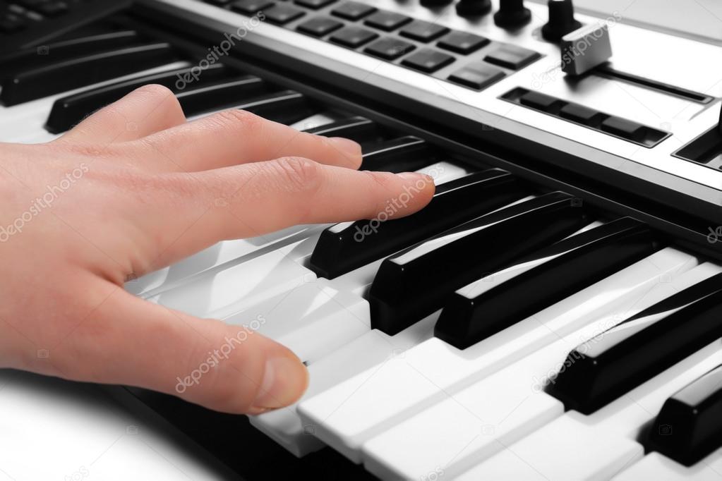 Male hand playing of synthesizer