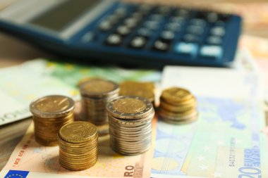 Para kavramı. Siyah hesaplayıcıyla banknot ve madeni paralar, yakın çekim