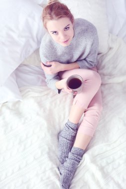 Bir fincan çay tutan kadın.