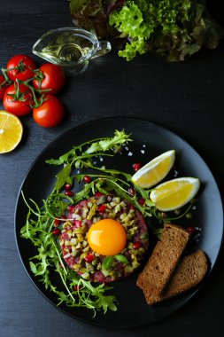 Biftek tartare croutons yuvarlak tabakta servis, yakın çekim