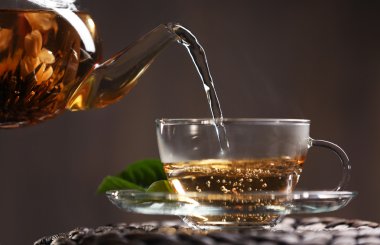 Çay Kupası karanlık bir arka plan üzerinde dökme