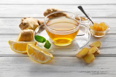 Cam bardak yeşil çay limon ve zencefil kökü üzerinde ahşap arka plan ile