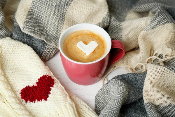 Tasse de cappuccino chaud avec guimauve cardiaque et vêtements chauds, gros plan — Photo