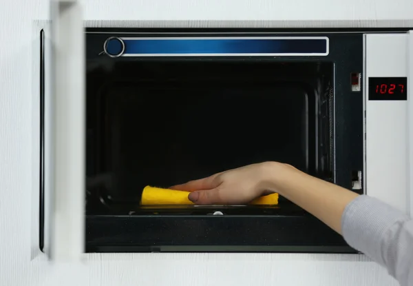 Vrouwelijke hand schoonmaak magnetron — Stockfoto