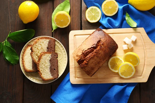 Delicious kue roti manis dengan lemon di atas meja kayu, top view — Stok Foto