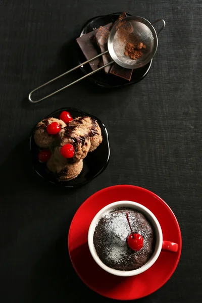 Шоколадний торт у червоній кухольці з вишнею зверху, вид зверху — стокове фото