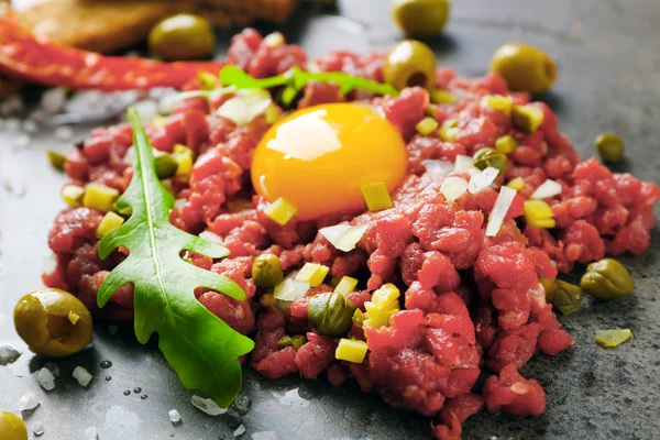 Rindfleisch-Tatar mit Croutons auf grauer Oberfläche, Nahaufnahme — Stockfoto