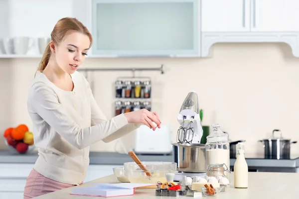 Vrouw kraken een ei tot een deeg — Stockfoto