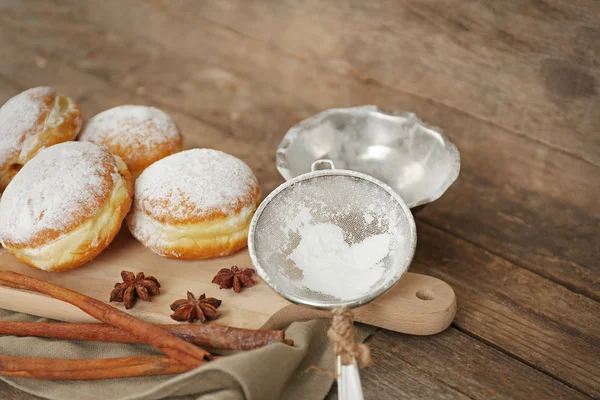 Delicious sugary donuts with spices on wooden background — Stock Photo, Image