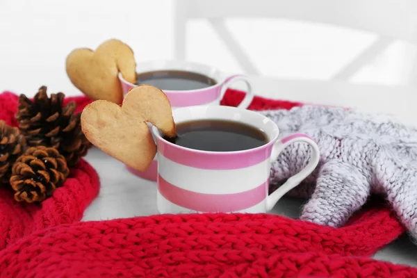 Biscotto a forma di cuore sulla tazza di caffè con sciarpa rossa a maglia primo piano — Foto Stock