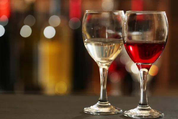 Glasses of red and white wine against blurred background — Stock Photo, Image