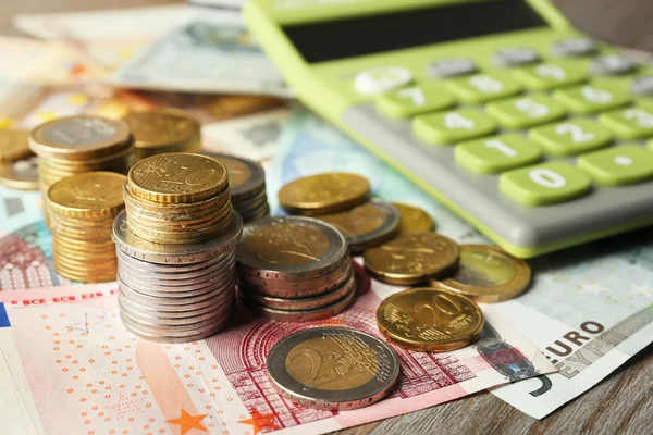 Calculator with banknotes and coins — Stock Photo, Image