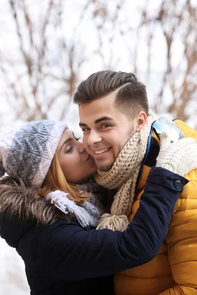 Young woman kissing her boyfriend outdoors — Stock Photo, Image