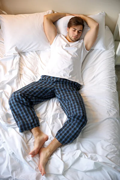 Jeune homme dormir dans le lit — Photo