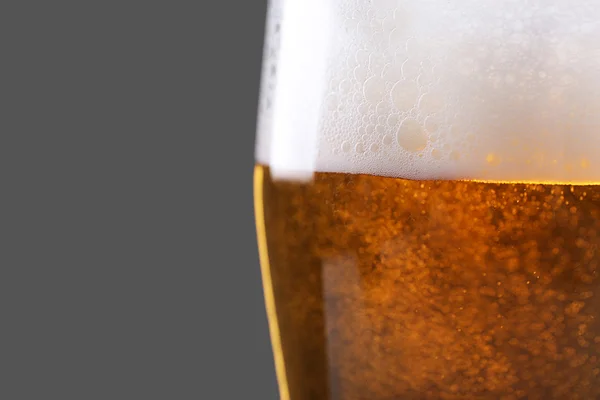 Glass of lager beer on grey background, close up — Stock Photo, Image