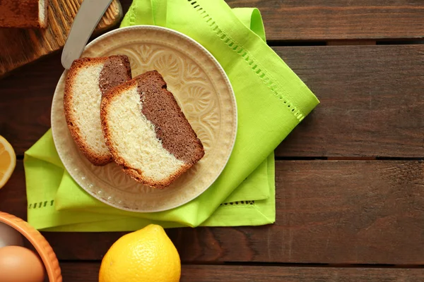 Вкусный сладкий торт хлеб в тарелке на деревянном столе, вид сверху — стоковое фото