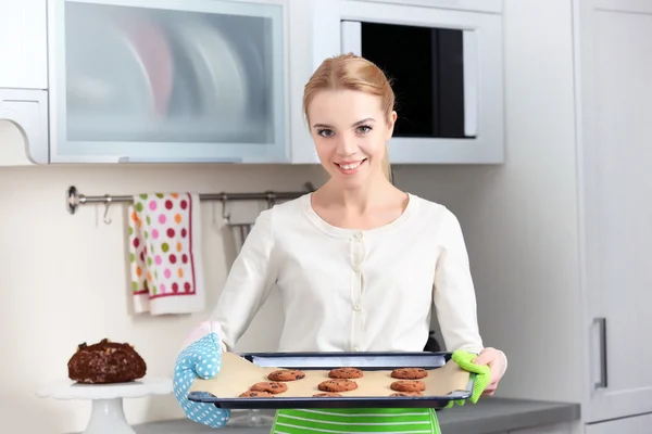 Young woman holding a cookie tray — Stock Photo, Image