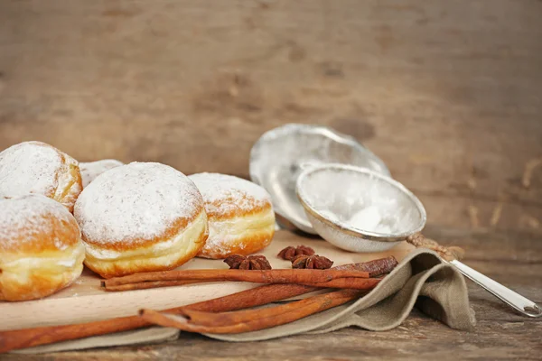 Смачні солодкі пончики зі спеціями на дерев'яному фоні — стокове фото