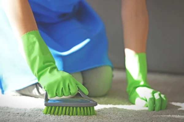 Mujer limpia alfombra en la habitación —  Fotos de Stock