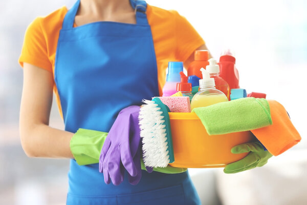 женщина держит жидкости для мытья
