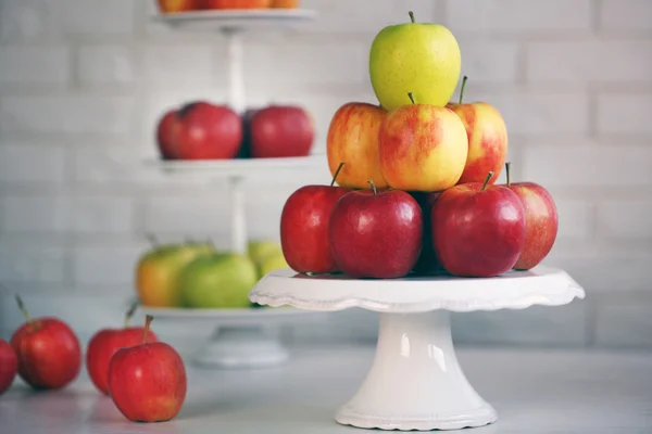 Ripe apples on stand on kitchen table — Stock Photo, Image