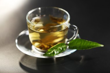 Koyu arkaplanda bir fincan yeşil çay