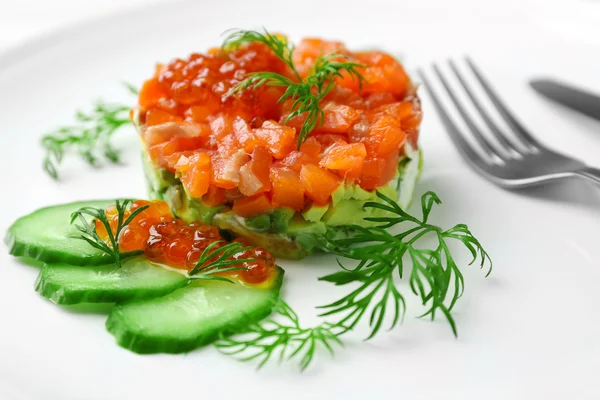 Delicioso tártaro de salmón con caviar rojo en plato blanco —  Fotos de Stock