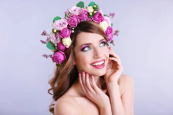 Mulher bonita vestindo headband floral em um fundo cinza — Fotografia de Stock