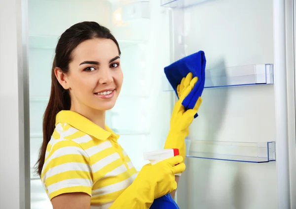 Woman washing refrigerator
