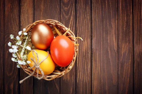 Huevos de Pascua en una canasta de mimbre, vista superior —  Fotos de Stock