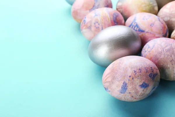 Œufs de Pâques sur une table bleue, vue sur le dessus — Photo