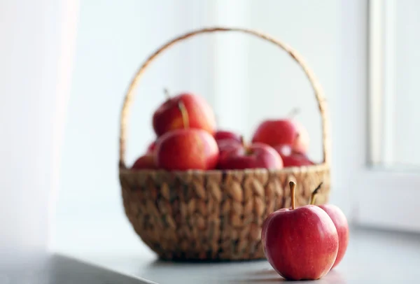Спелые красные яблоки в корзине на подоконнике — стоковое фото