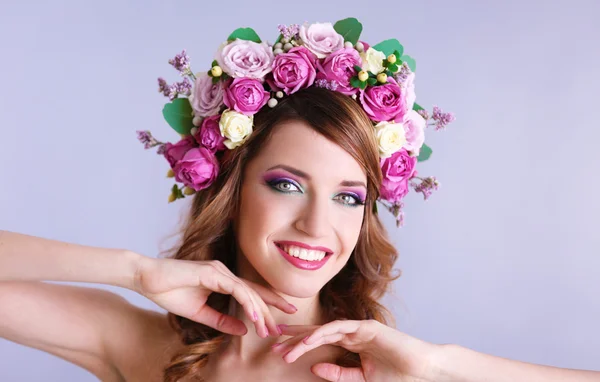 Mulher bonita vestindo headband floral em um fundo cinza — Fotografia de Stock