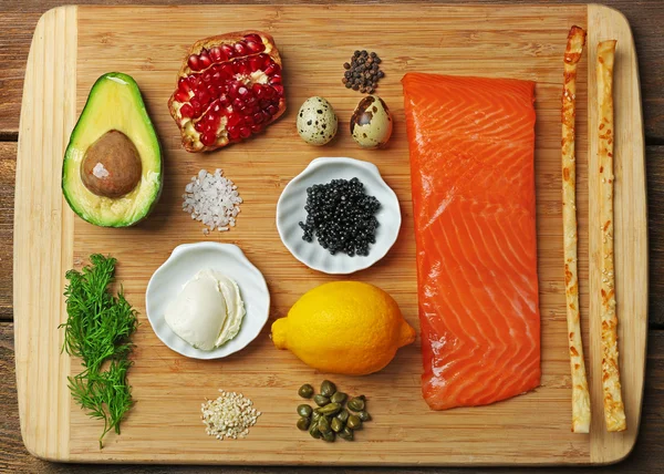 Smakelijke ingrediënten voor zalm tartaar op snijplank, plat leggen — Stockfoto