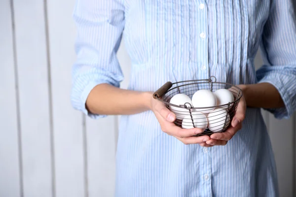 Œufs dans le panier dans les mains de la femme — Photo