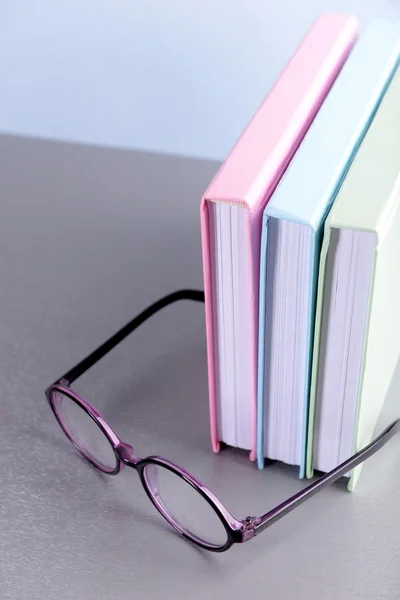 Книги и очки на сером столе — стоковое фото