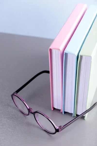 Livros e óculos sobre mesa cinzenta — Fotografia de Stock