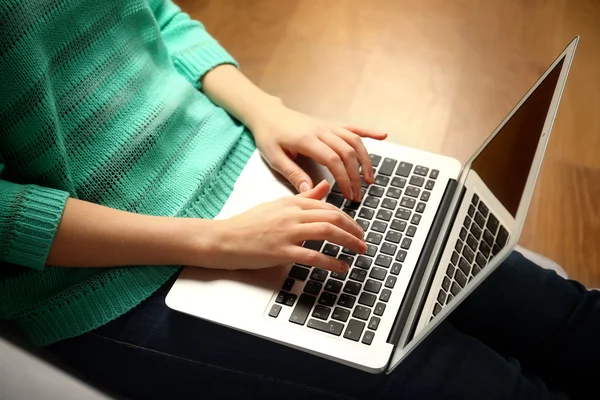 Femme assise sur canapé avec ordinateur portable — Photo