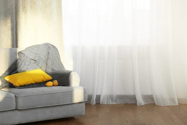 Серый диван с желтой подушкой — стоковое фото