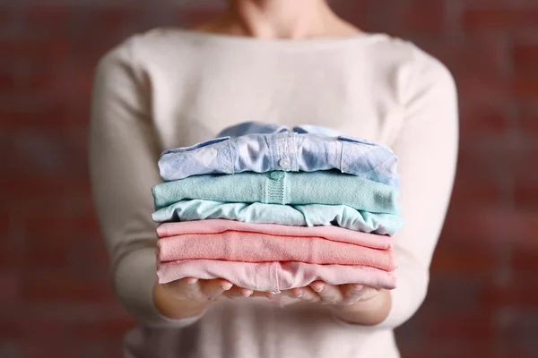 Mulher segurando roupas lavadas e secas — Fotografia de Stock