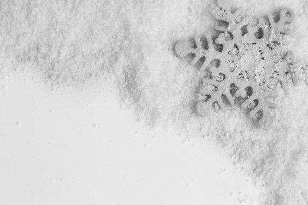 Снежинка на снежном фоне — стоковое фото