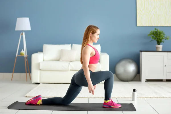 Esportista fazendo exercícios em um tapete — Fotografia de Stock